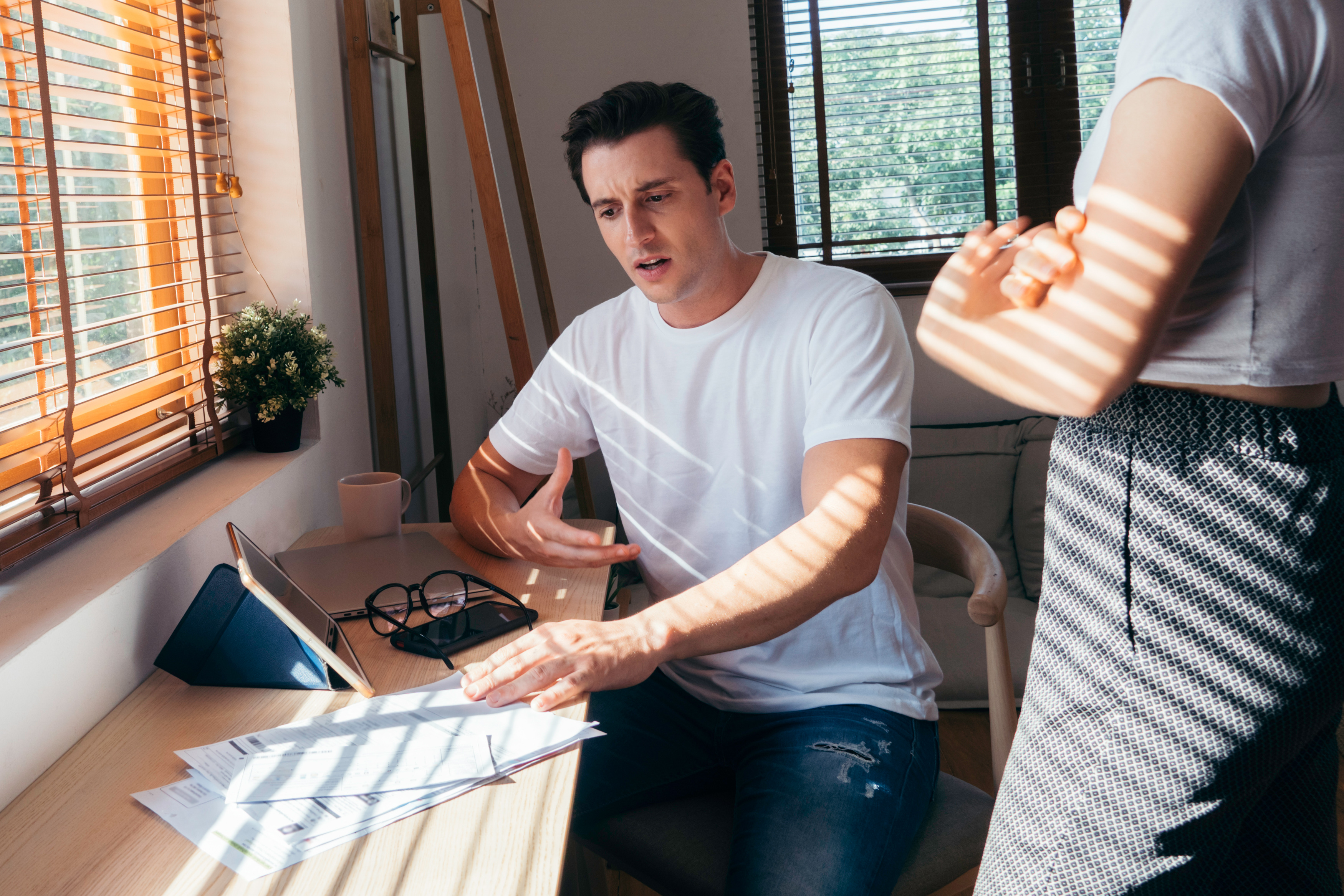 Stressed young Caucasian couple discussing about bills debt document at home. unhappy man arguing his wife, family financial problem during Coronavirus or Covid-19 outbreak crisis