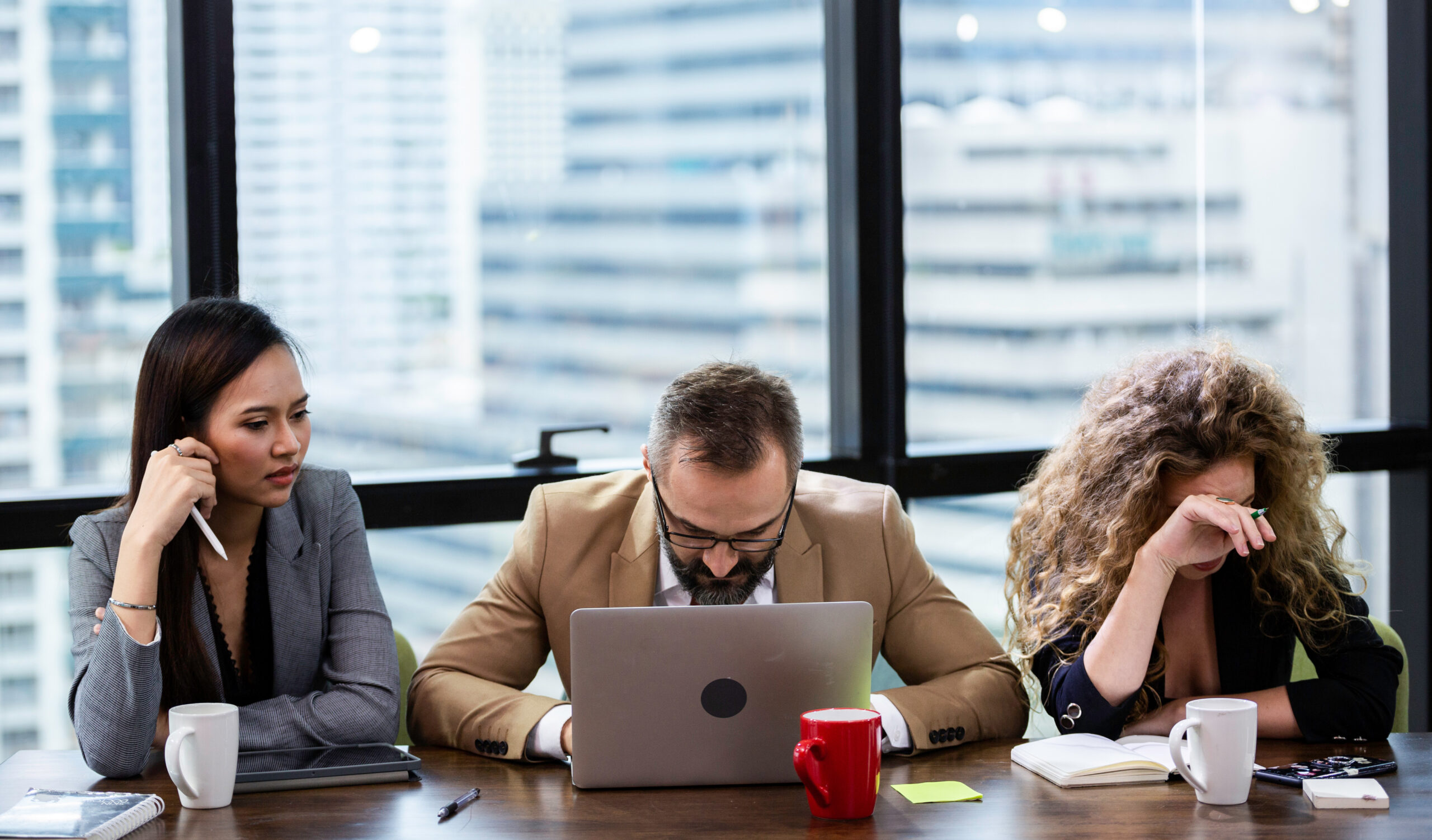 Group of businesspeople depressed from financial crisis. man checking business information in a laptop with woman brainstorm meeting to solve problem together in the office