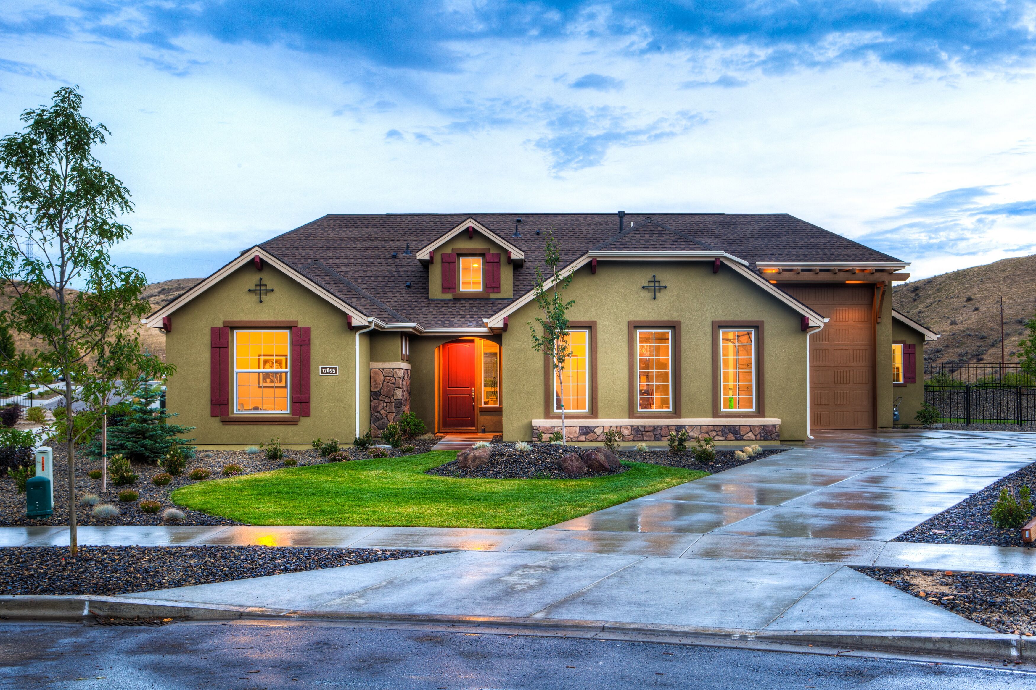 A warm and inviting modern house with well-maintained landscaping and exterior lighting highlighting the house's features