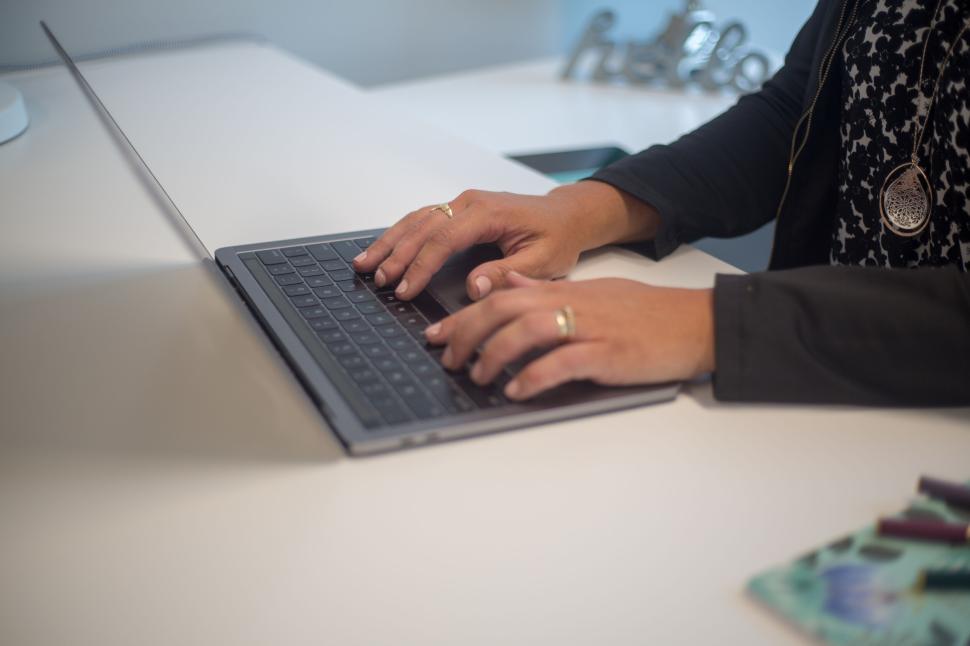 Woman typing on a computer at a minimal desk.