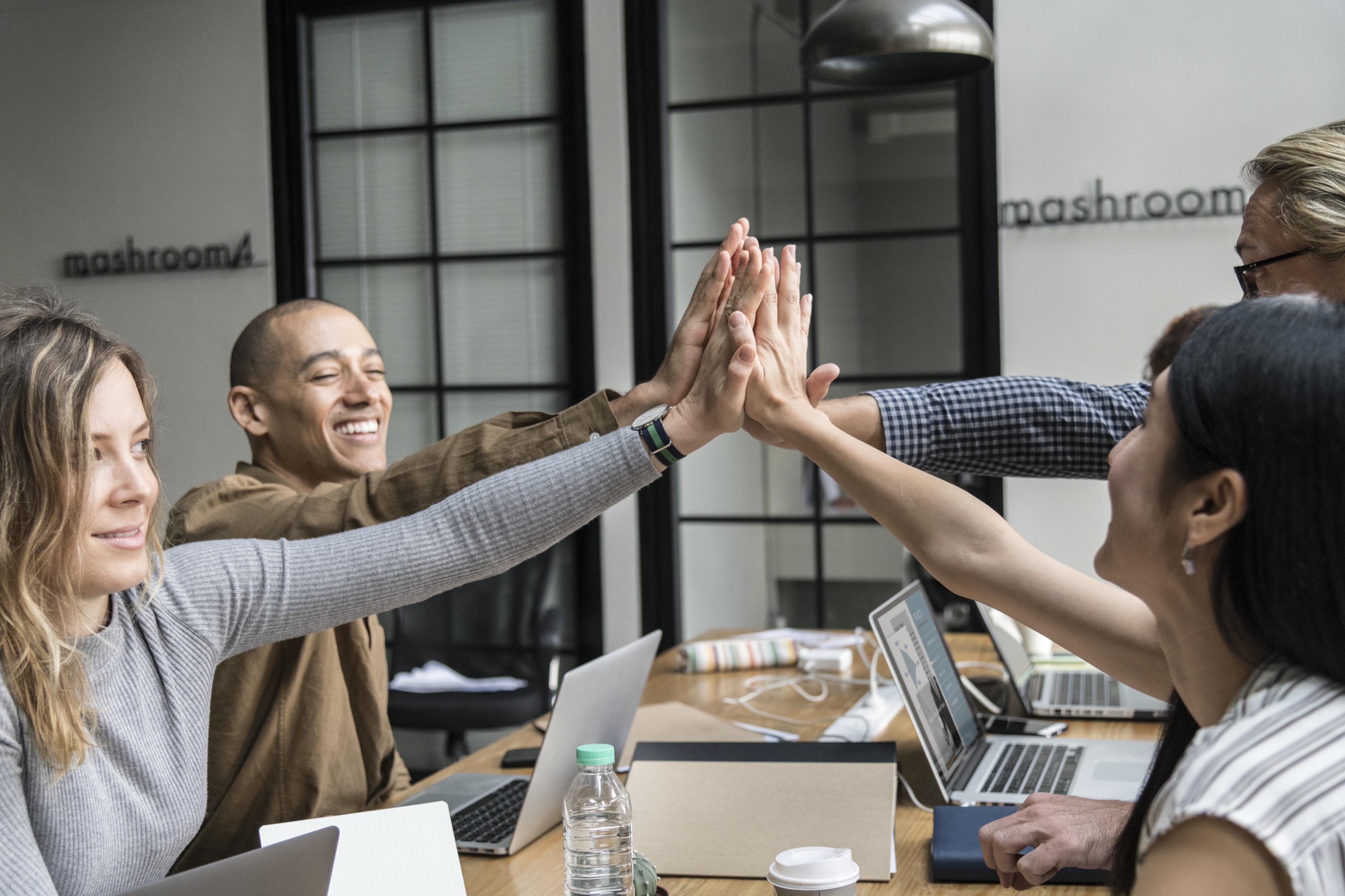 A group of multiethnic colleagues giving high five in the office