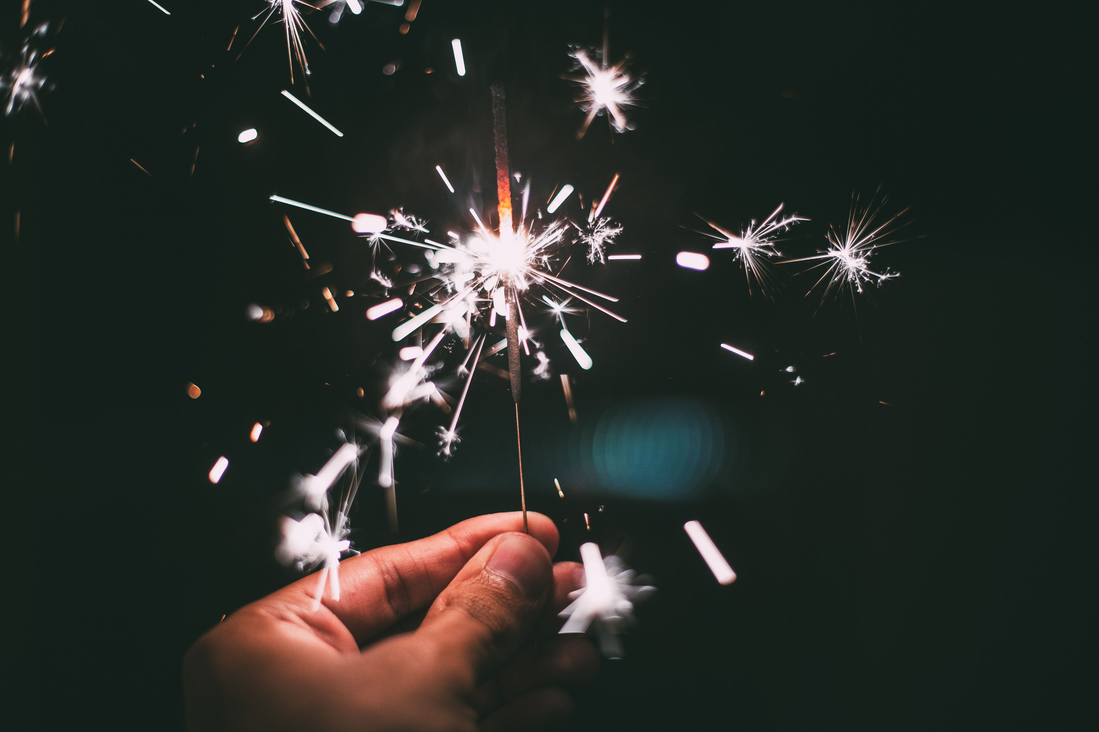 Hand holder a lit sparkler in the dark for a New Year celebration