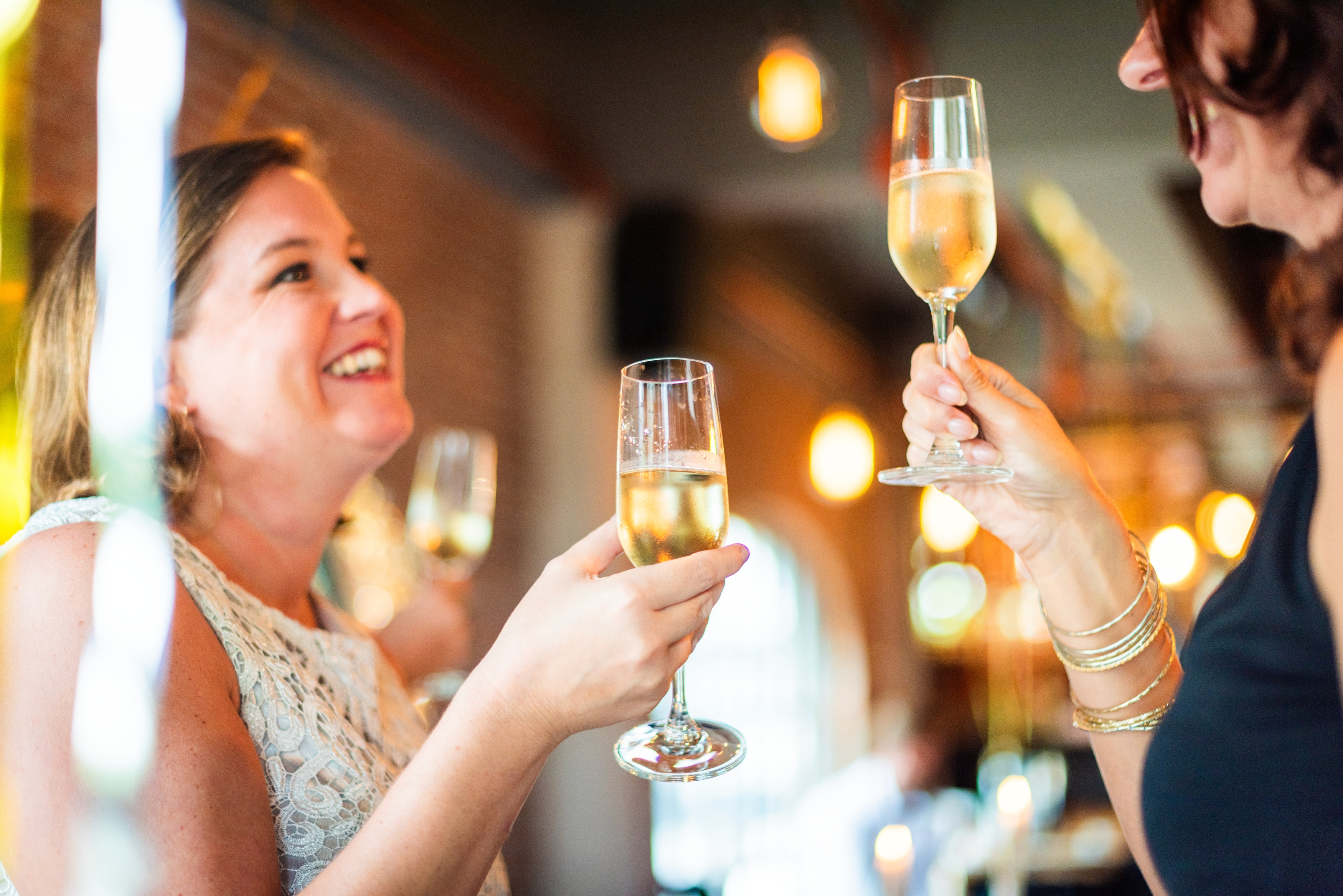 Two women enjoying a celebration with champagne glasses, smiling and toasting.