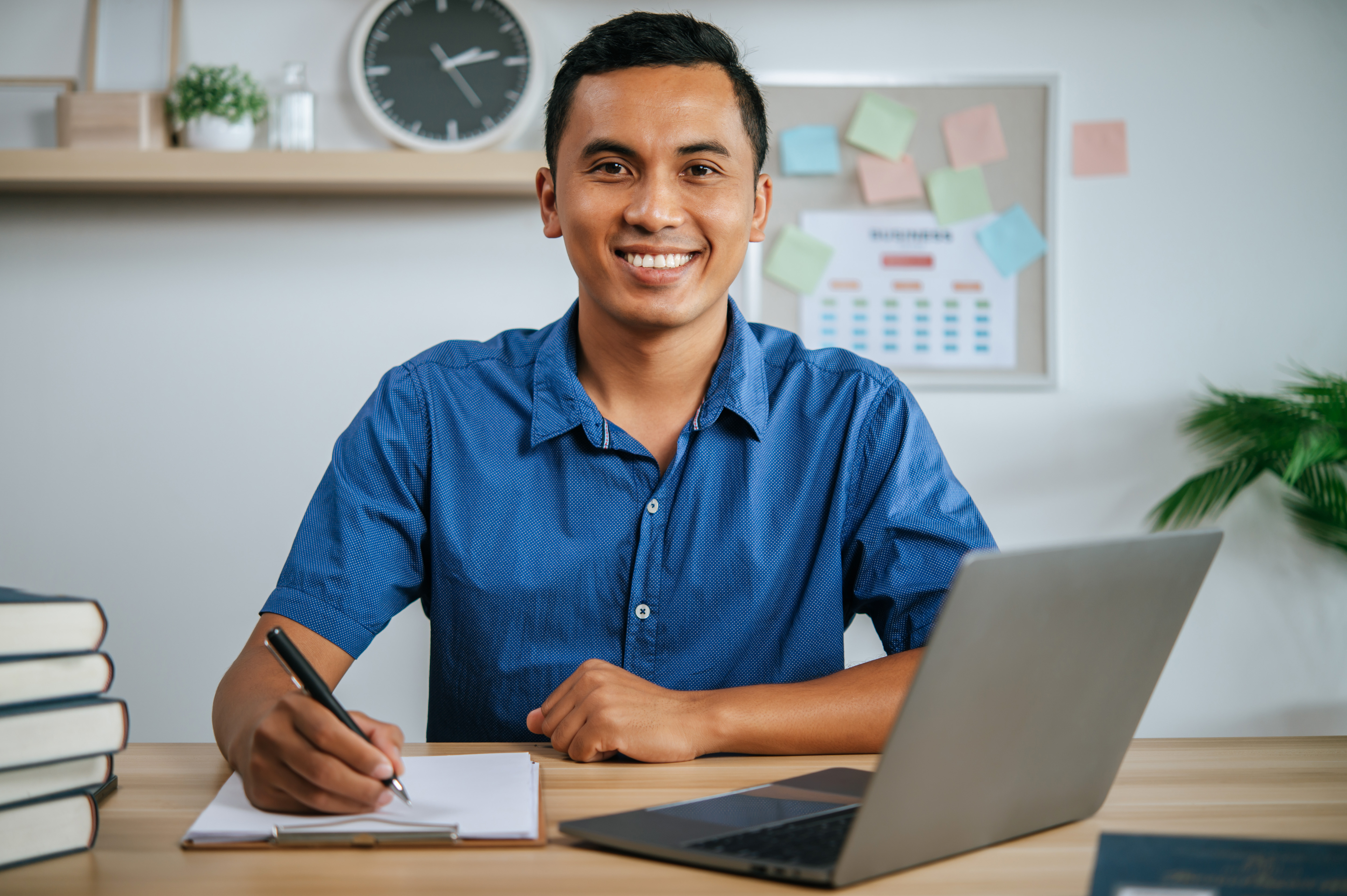 A man working in office with papers and laptop on desk